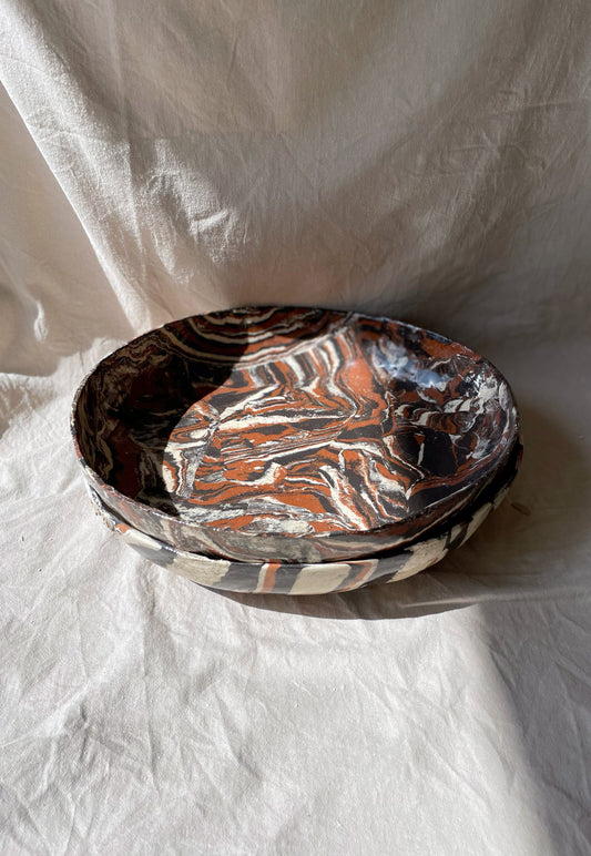 Two marbled ceramic bowls from the Ardi collection with earthy hues and clear glaze, stacked, side angle